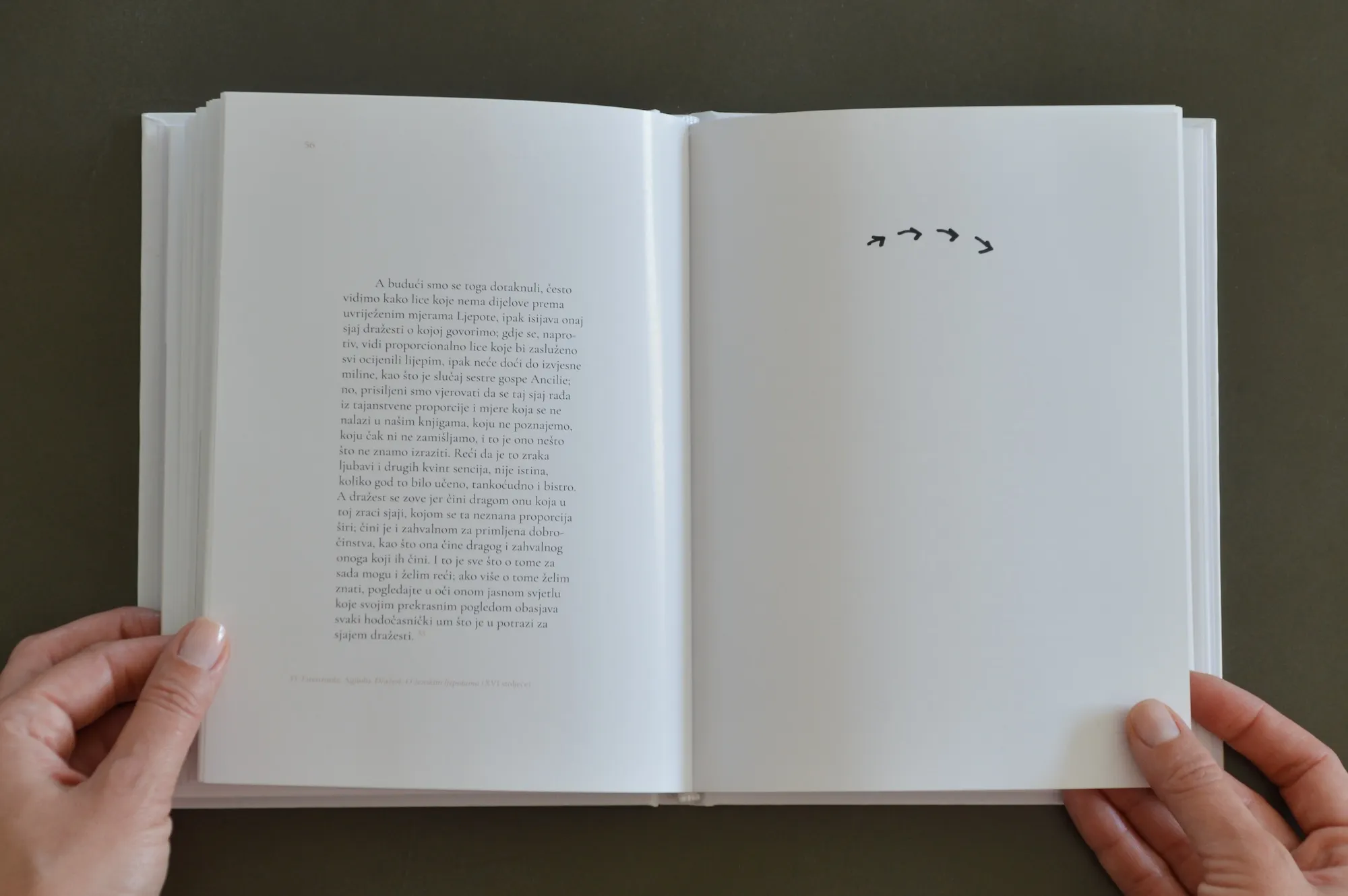 Book spread with a quoted passage on beauty and grace, and small hand-drawn arrow marks.