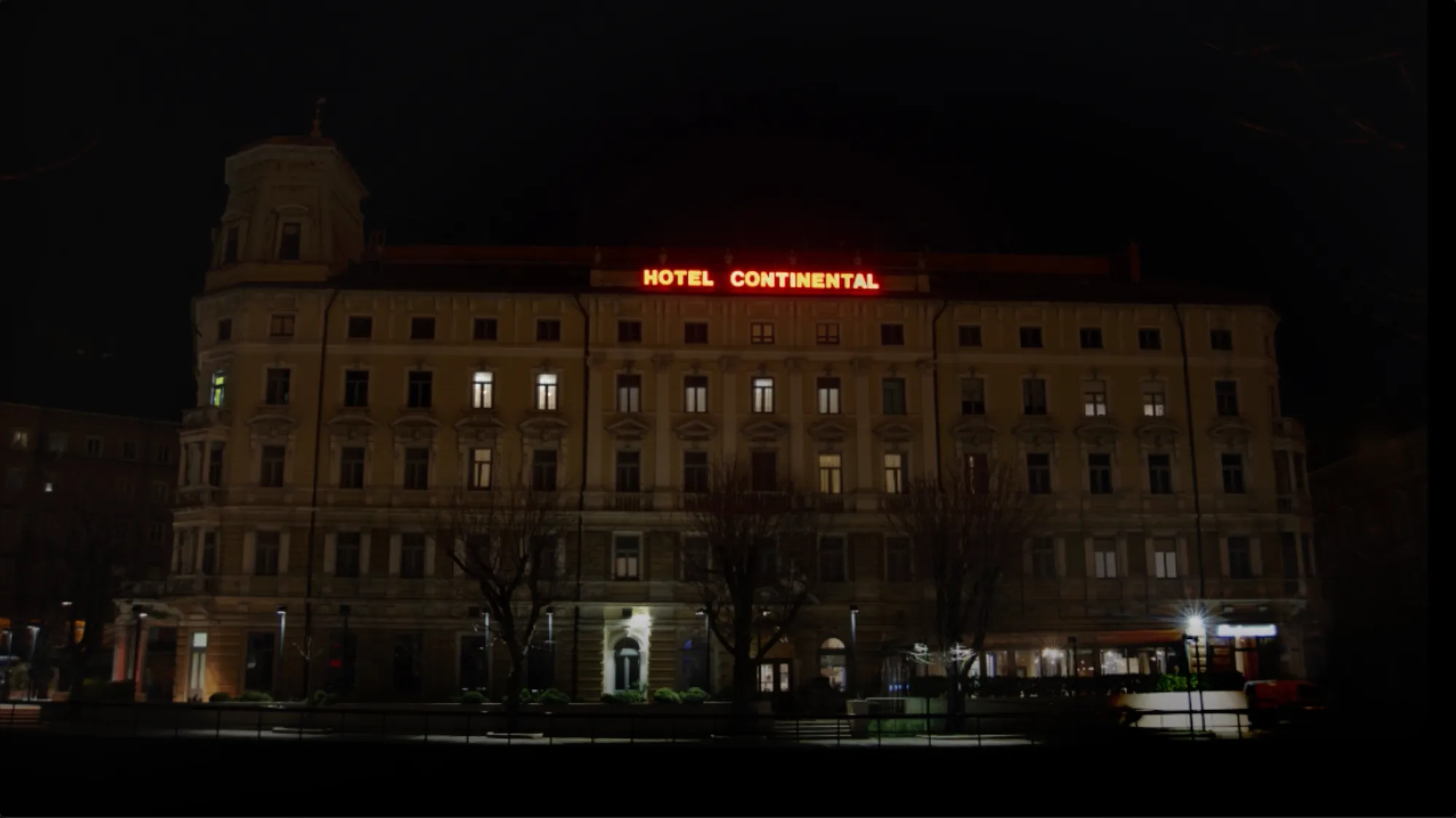 Night photograph of the Hotel Continental building with its illuminated rooftop sign reading "HOTEL CONTINENTAL".