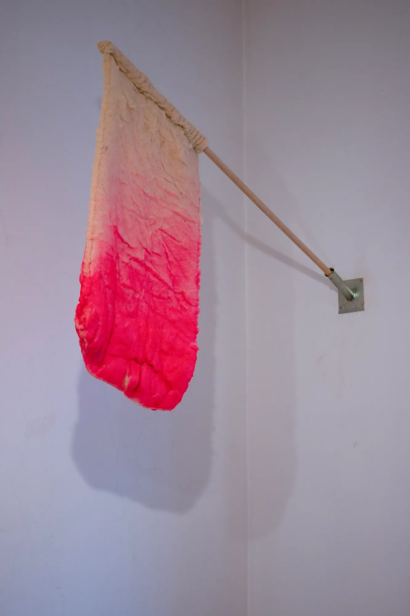 Side view of the felted wool flag mounted on a wall bracket.