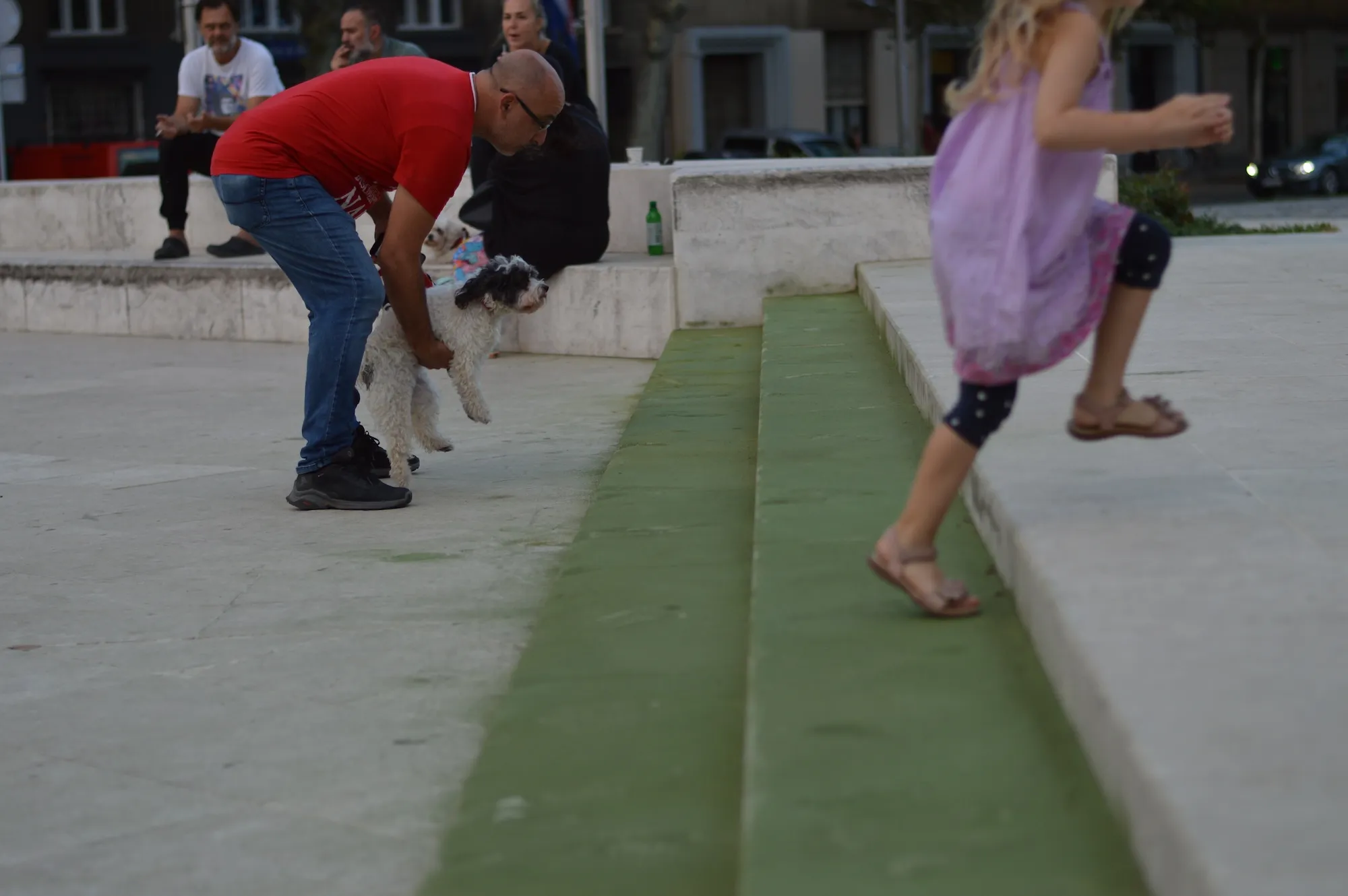 Glass jars of green powder residue and a sieve resting on the pavement beside the fountain.